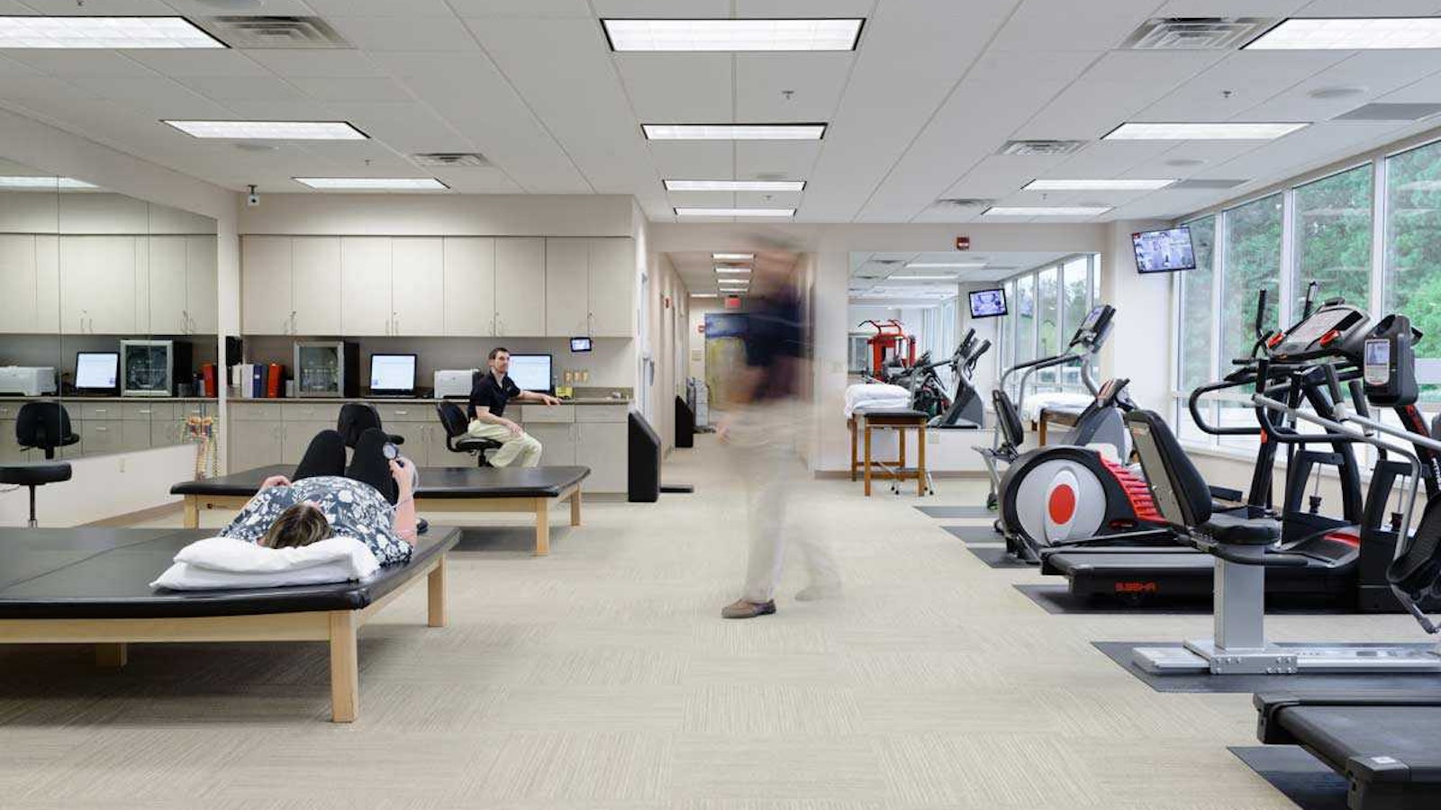 Blurred man walking through a physical therapy room
