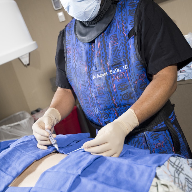 Dr. Polk in Scrubs Performing a Pain Block at Semmes Murphey Clinic