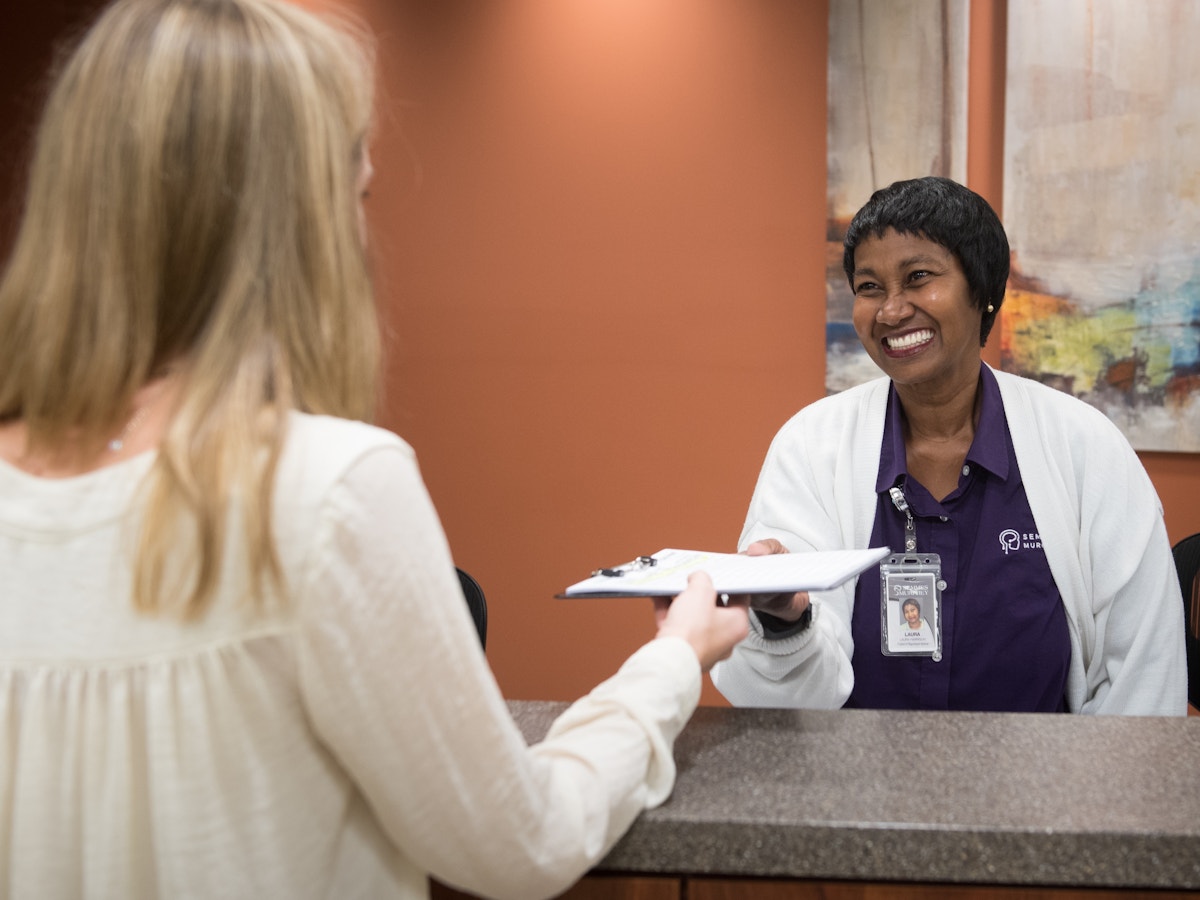 Friendly receptionist helps a patient check in