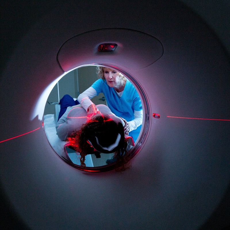 patient laying on a ct machine in a dark room