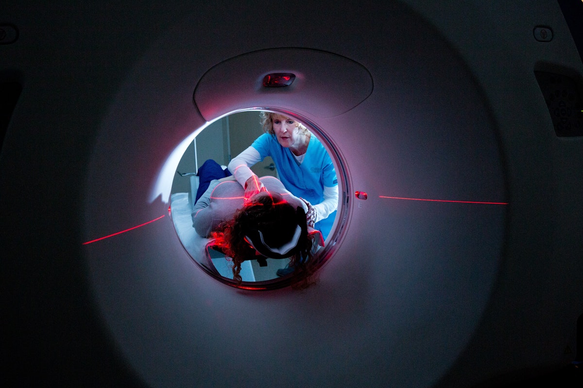patient laying on a ct machine in a dark room